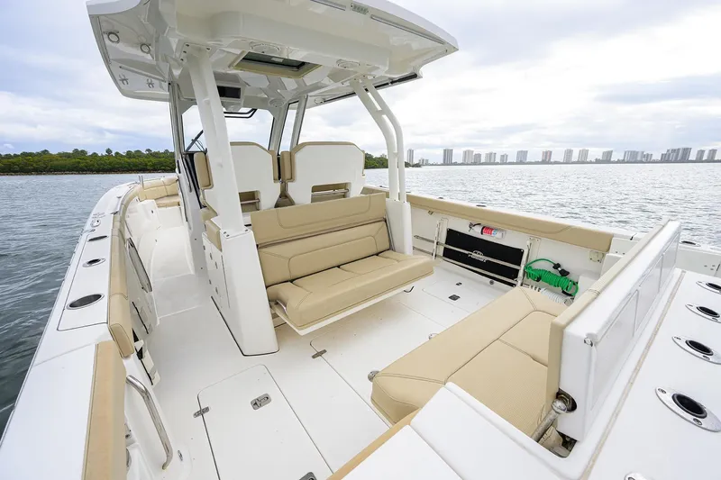  Yacht Photos Pics 2019 Pursuit S 328 Sport boat interior with beige seating, on a calm water backdrop.