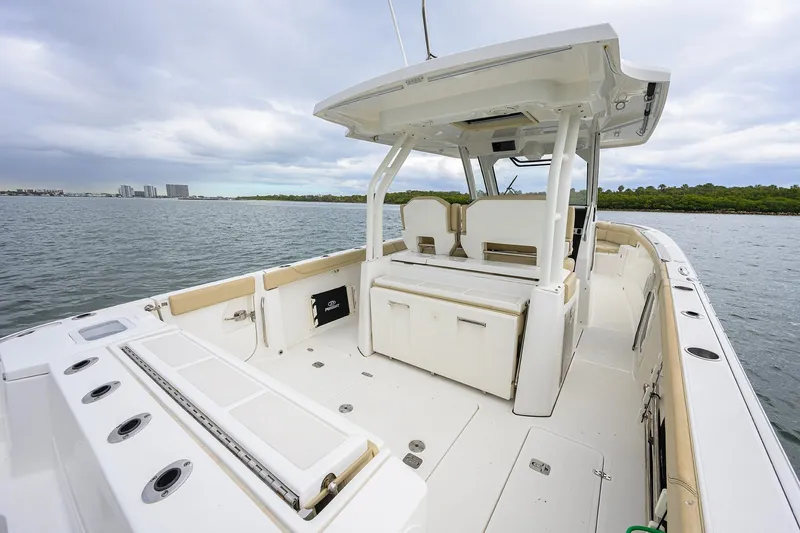  Yacht Photos Pics 2019 Pursuit S 328 Sport boat interior with spacious deck and seating, on calm waters.
