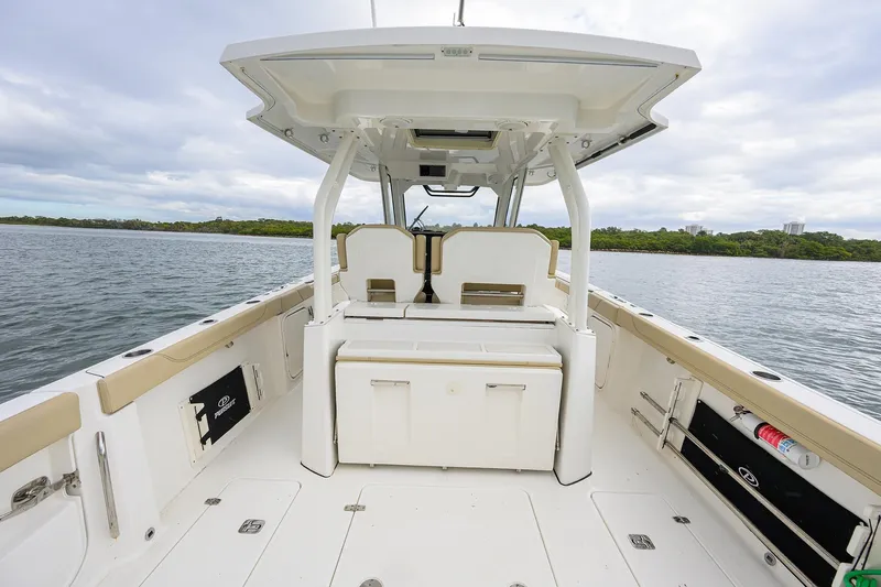  Yacht Photos Pics 2019 Pursuit S 328 Sport boat interior with seating and storage, on calm water.