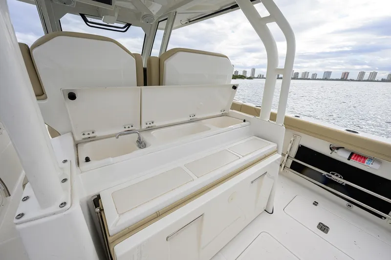  Yacht Photos Pics 2019 Pursuit S 328 Sport boat interior with seating and storage, overlooking waterfront skyline.
