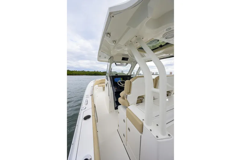  Yacht Photos Pics 2019 Pursuit S 328 Sport boat interior with helm and seating, on calm water.