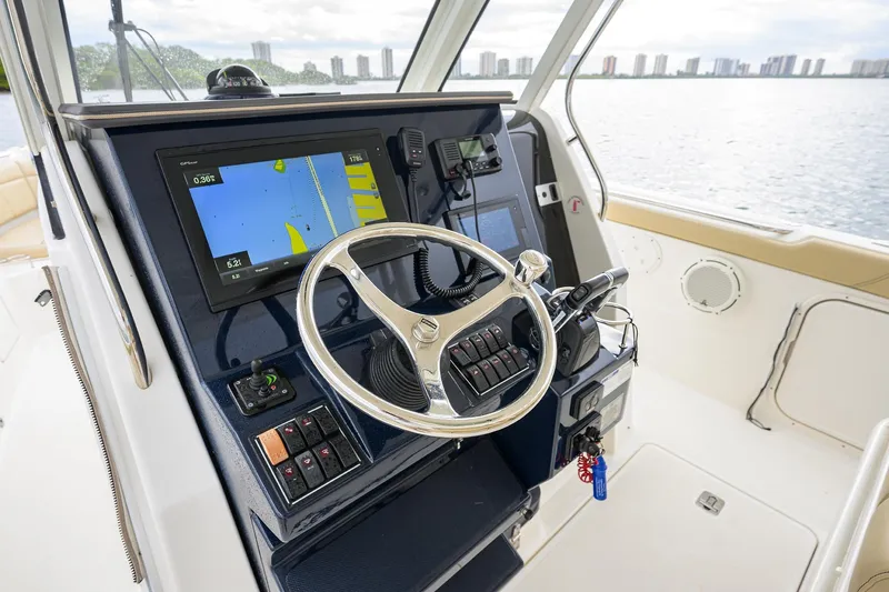  Yacht Photos Pics 2019 Pursuit S 328 Sport boat helm with navigation display and steering wheel.