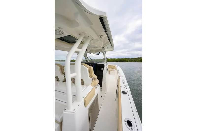  Yacht Photos Pics 2019 Pursuit S 328 Sport boat interior with seating and canopy on calm water.