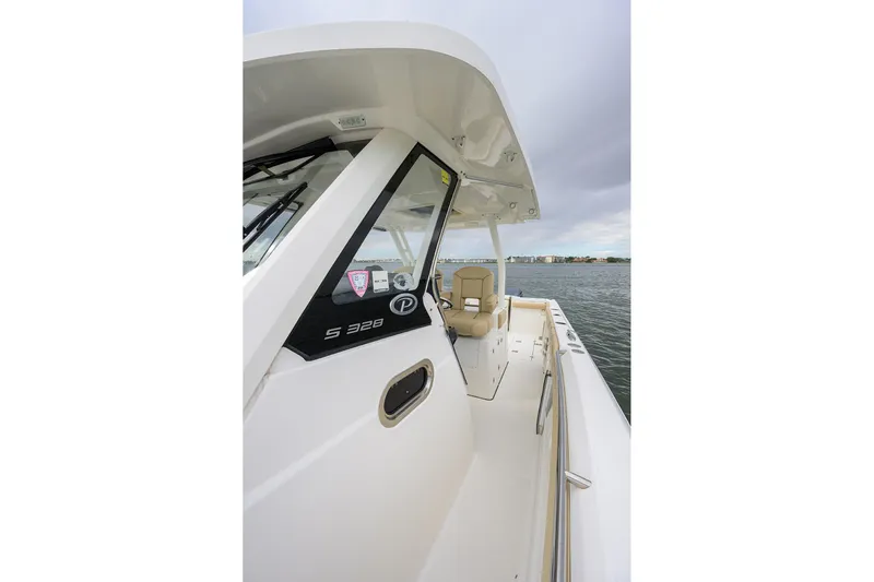  Yacht Photos Pics 2019 Pursuit S 328 Sport boat on water, showcasing sleek design and spacious deck.