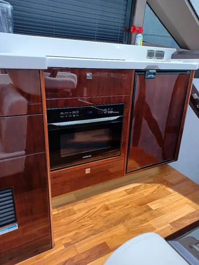 Must Sell, Make An Offer Yacht Photos Pics 2022 Galeon 410 HTC yacht interior with wood cabinetry and modern appliances.