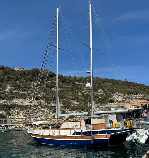 Hama Yacht Photos Pics Custom 1994 ABATS Gulet Ketch docked in a scenic harbor with hills in the background.