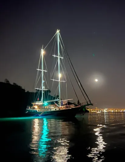 Hama Yacht Photos Pics Sailing yacht "ABATS GULET KETCH" illuminated at night, reflecting on calm water.