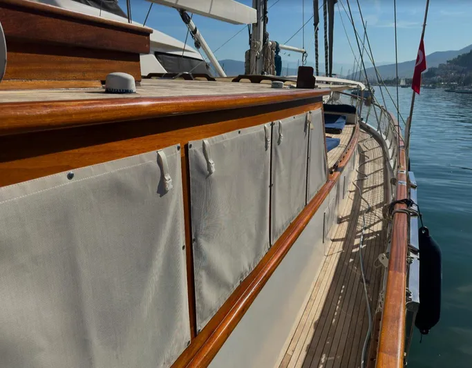 Hama Yacht Photos Pics Wooden deck of 1994 Custom ABATS Gulet Ketch yacht with canvas covers, docked by calm waters.