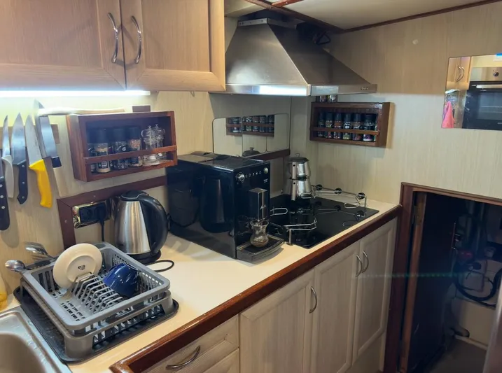 Hama Yacht Photos Pics Compact kitchen in a 1994 Custom ABATS Gulet Ketch, featuring modern appliances and organized storage.