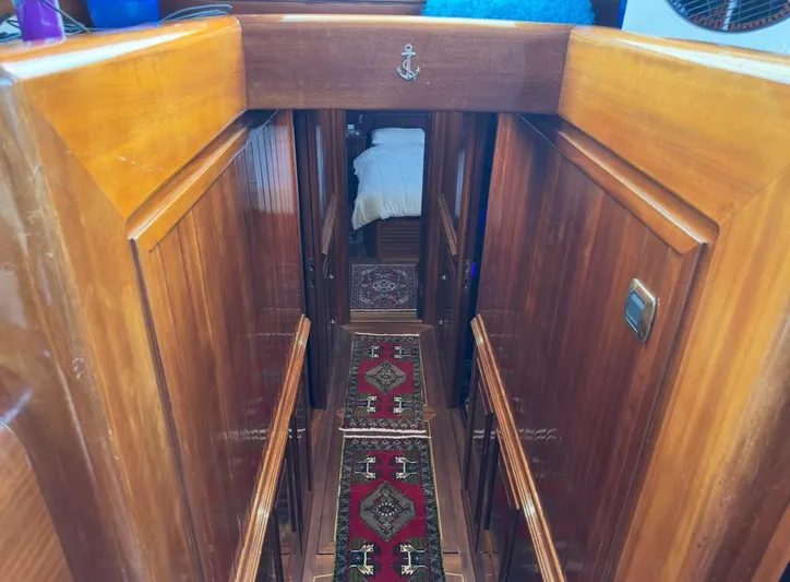 Hama Yacht Photos Pics Wooden interior hallway of 1994 Custom ABATS Gulet Ketch with decorative rug and bed.
