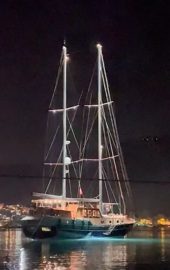 Hama Yacht Photos Pics Custom ABATS Gulet Ketch 1994 sailing at night with illuminated masts and calm waters.