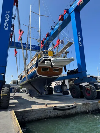 Hama Yacht Photos Pics Custom 1994 ABATS Gulet Ketch yacht in dry dock, supported by blue cranes.