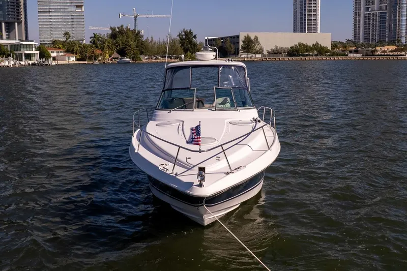Island Time II Yacht Photos Pics 2005 Four Winns 378 Vista yacht on water, city skyline in background.