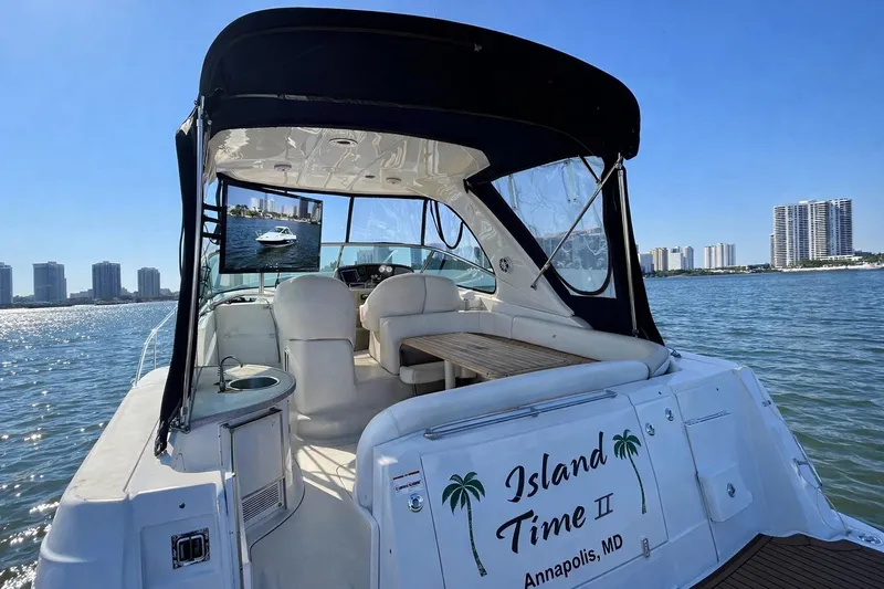 Island Time II Yacht Photos Pics 2005 Four Winns 378 Vista yacht on water, featuring spacious seating and city skyline backdrop.