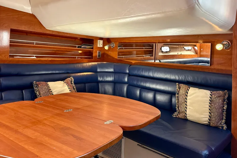 Island Time II Yacht Photos Pics Luxurious 2005 Four Winns 378 Vista yacht interior with blue leather seating and wooden table.