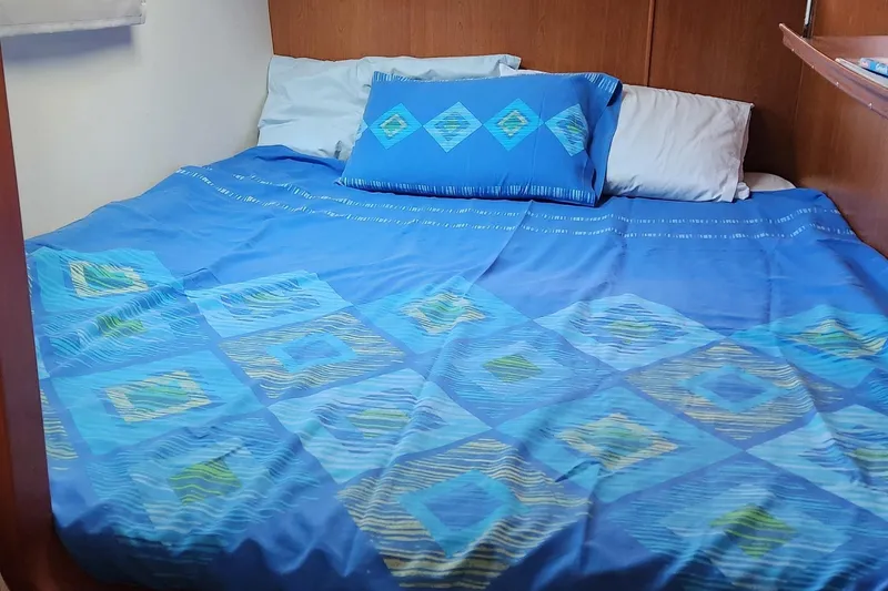  Yacht Photos Pics Cozy bed with blue geometric-patterned bedding in a 2007 Leopard 40 yacht cabin.