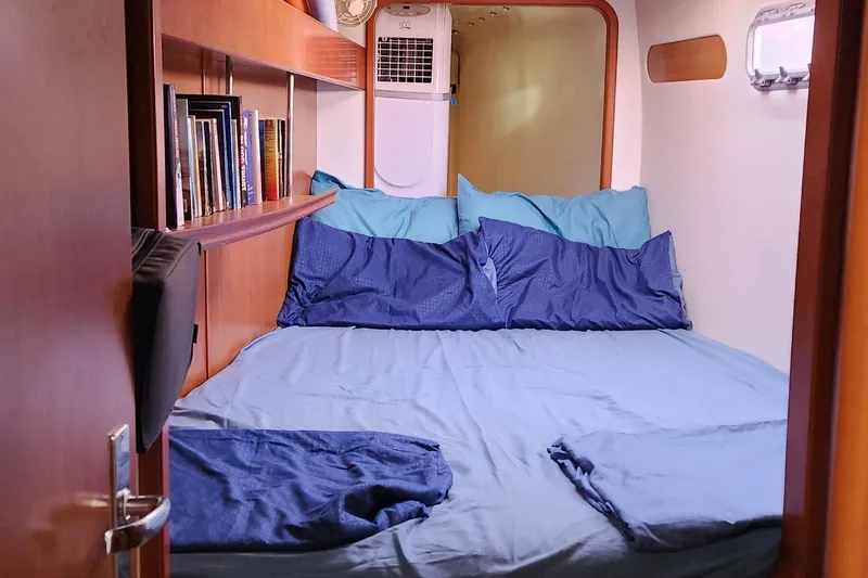  Yacht Photos Pics Cozy cabin bedroom in 2007 Leopard 40 yacht with blue bedding and bookshelf.