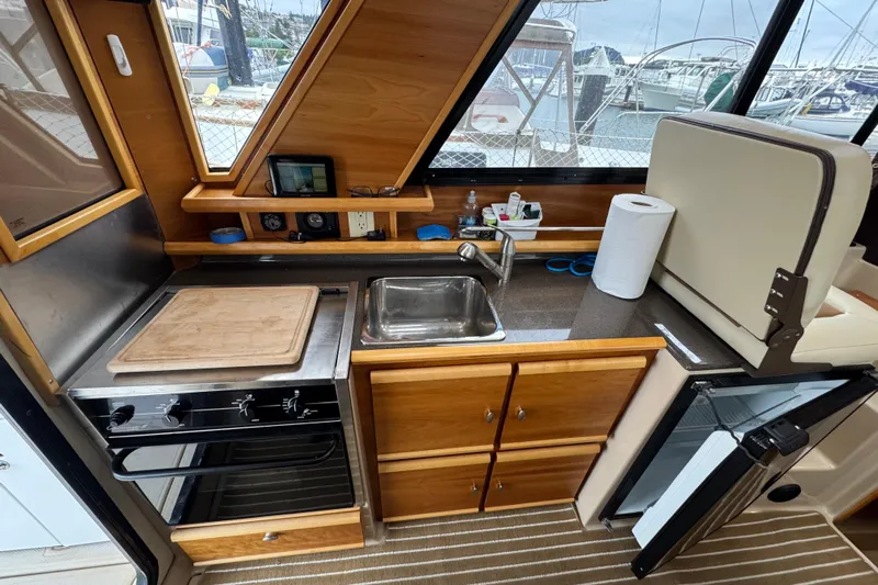  Yacht Photos Pics 2014 Cutwater 28 boat interior kitchen with stove, sink, and storage cabinets.