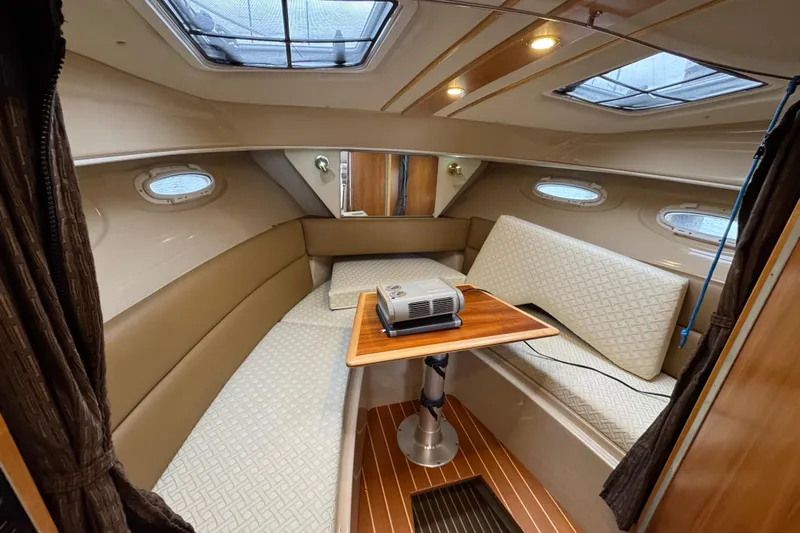  Yacht Photos Pics Interior of 2014 Cutwater 28 boat with cozy seating and wooden table.