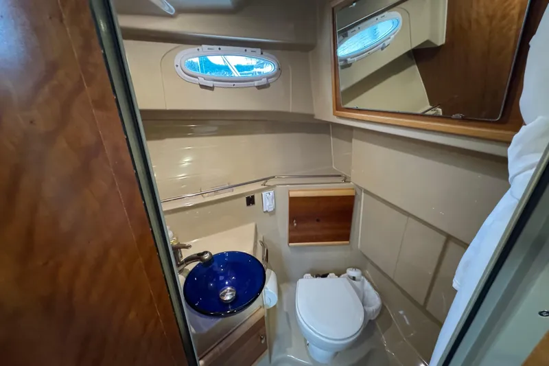  Yacht Photos Pics 2014 Cutwater 28 boat bathroom with blue sink, toilet, and mirror.