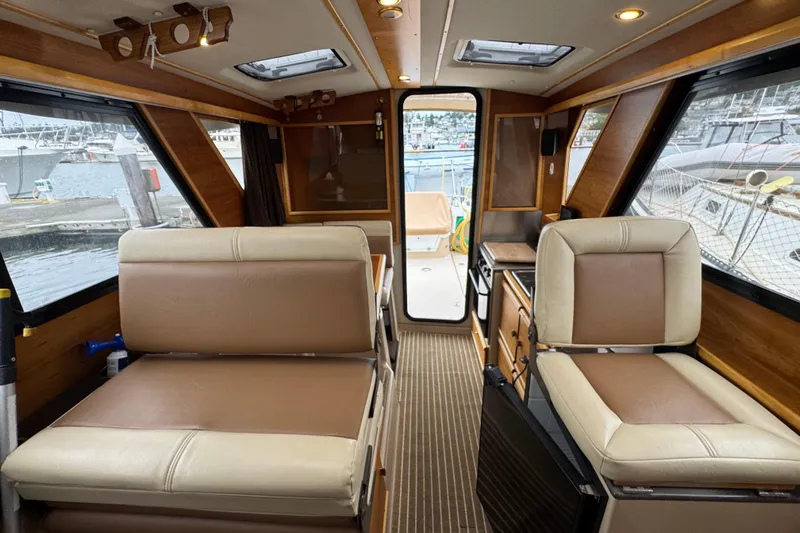  Yacht Photos Pics Interior of a 2014 Cutwater 28 boat with beige seating and wood accents.
