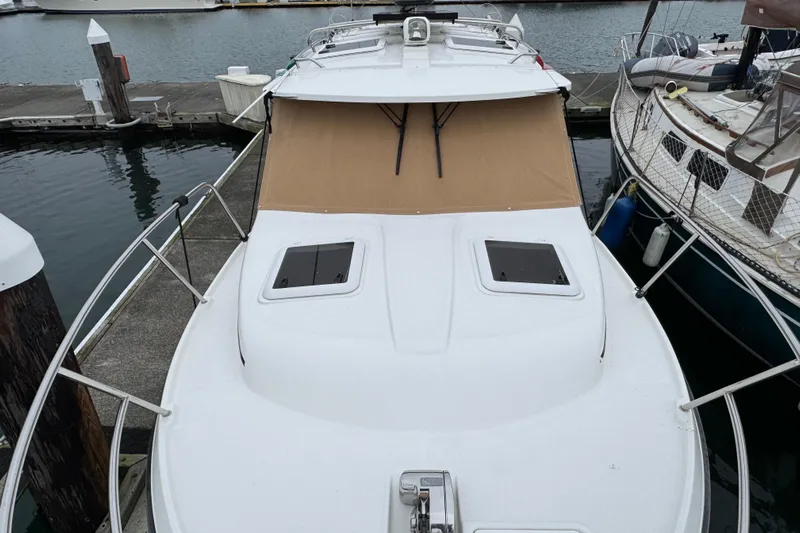  Yacht Photos Pics 2014 Cutwater 28 boat docked at marina, featuring sleek white deck and tan cover.
