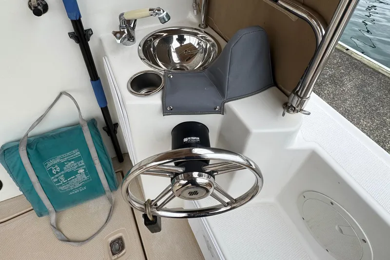  Yacht Photos Pics 2014 Cutwater 28 boat helm with steering wheel, sink, and safety equipment.