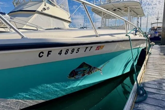  Yacht Photos Pics 1997 Marlin Yachts 350SF docked, featuring vibrant hull design and registration number.