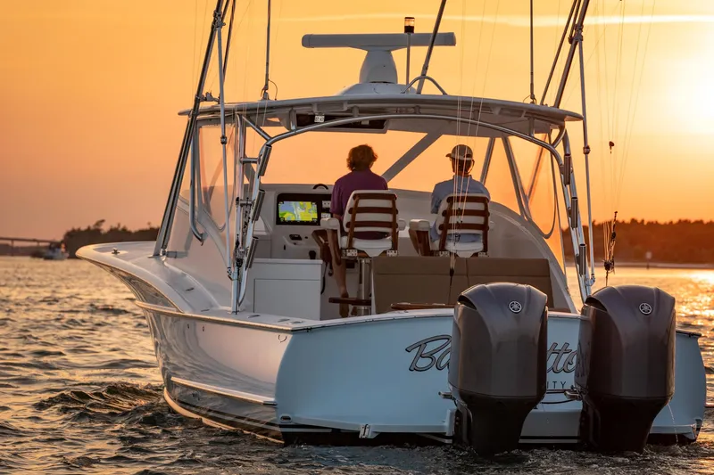Hawk's Nest Yacht Photos Pics 2012 Shearline 34' Express boat cruising at sunset with two people onboard.