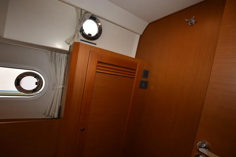 Yacht Photos Pics Interior of 2023 Beneteau Swift Trawler 41 Fly with wooden paneling and porthole windows.