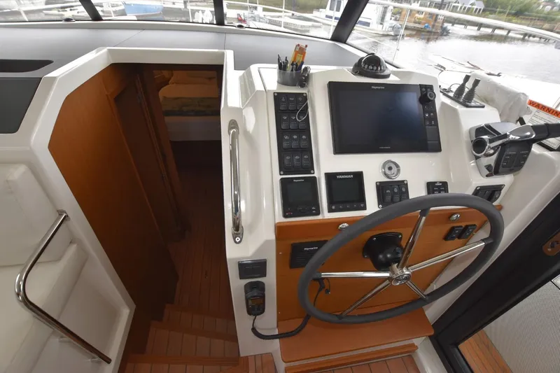  Yacht Photos Pics 2023 Beneteau Swift Trawler 41 Fly helm station with navigation controls and steering wheel.