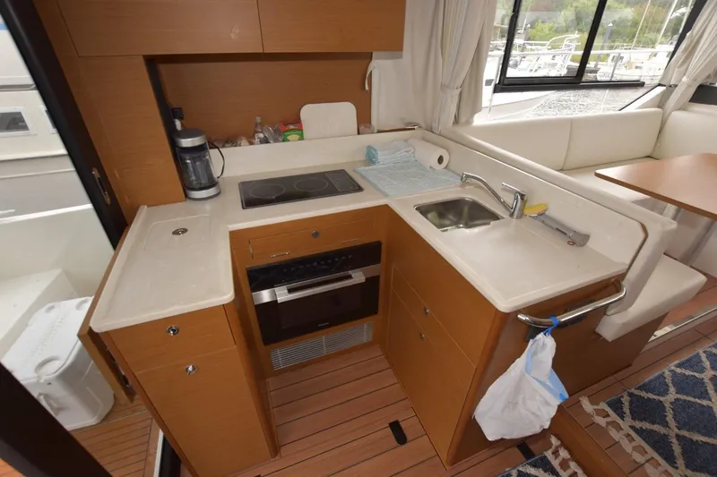  Yacht Photos Pics 2023 Beneteau Swift Trawler 41 Fly kitchen with modern appliances and wood finish.