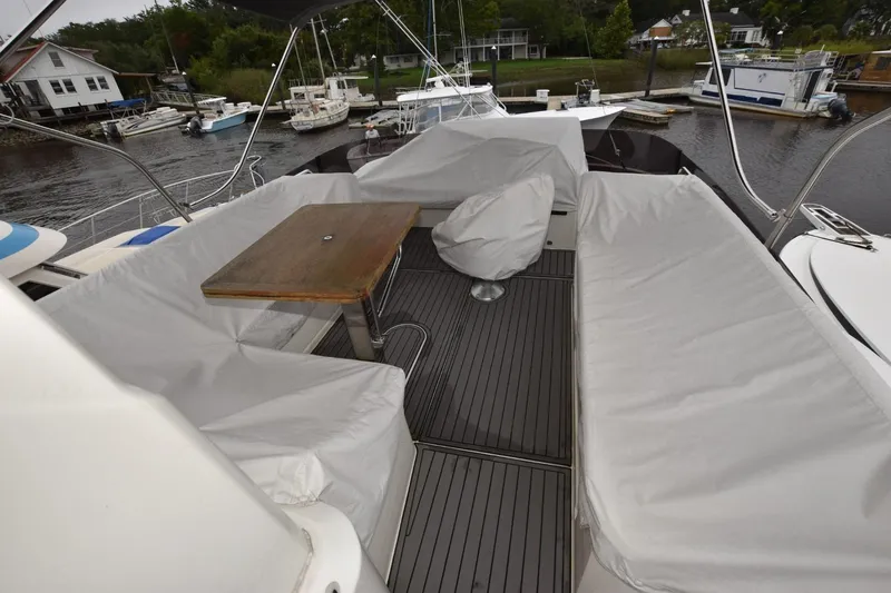  Yacht Photos Pics 2023 Beneteau Swift Trawler 41 Fly deck with covered seating and table, docked at marina.