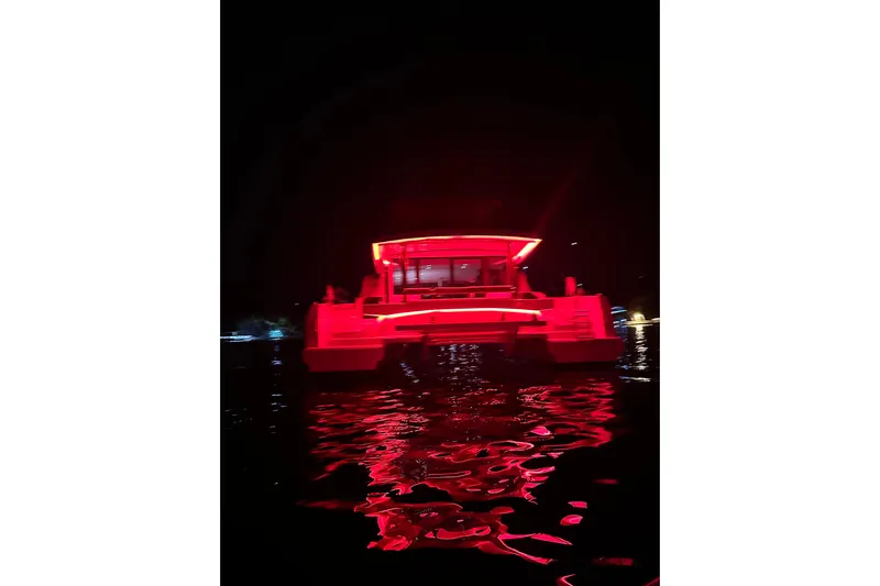 High 5 Yacht Photos Pics 2024 Bali 5.4 catamaran illuminated in red lights on water at night.