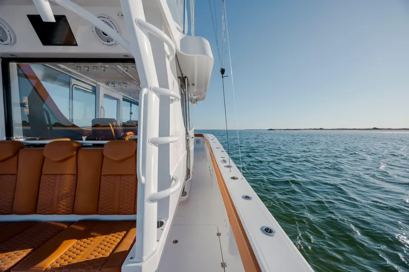  Yacht Photos Pics 2024 Invincible 46 Pilothouse yacht with luxurious seating, cruising on open water.