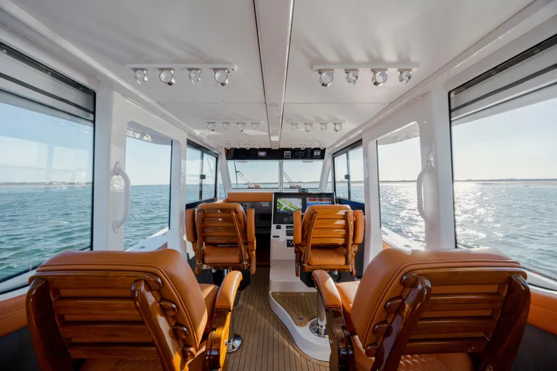  Yacht Photos Pics 2024 Invincible 46 Pilothouse interior with leather seats and panoramic ocean views.