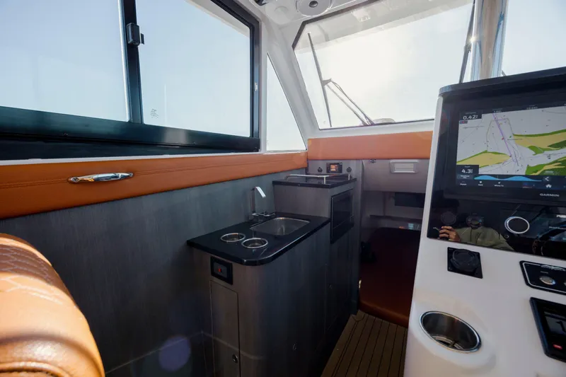  Yacht Photos Pics 2024 Invincible 46 Pilothouse interior with navigation display and compact kitchenette.