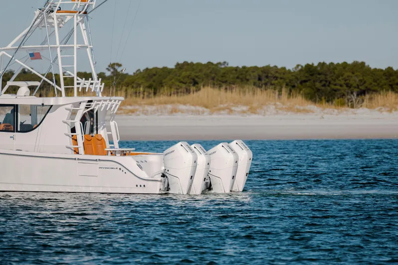  Yacht Photos Pics 2024 Invincible 46 Pilothouse boat with triple outboard engines on calm water.