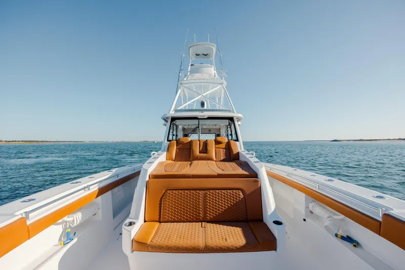  Yacht Photos Pics 2024 Invincible 46 Pilothouse yacht on open water, featuring luxurious seating and sleek design.