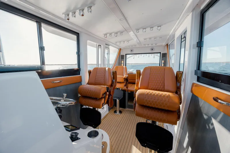  Yacht Photos Pics Luxurious interior of 2024 Invincible 46 Pilothouse with leather seating and panoramic windows.