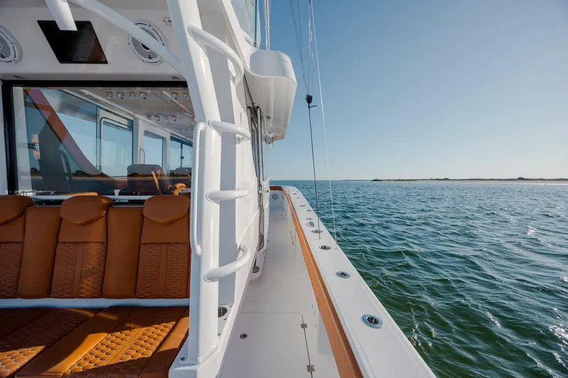  Yacht Photos Pics 2024 Invincible 46 Pilothouse yacht with luxurious seating, cruising on open water.