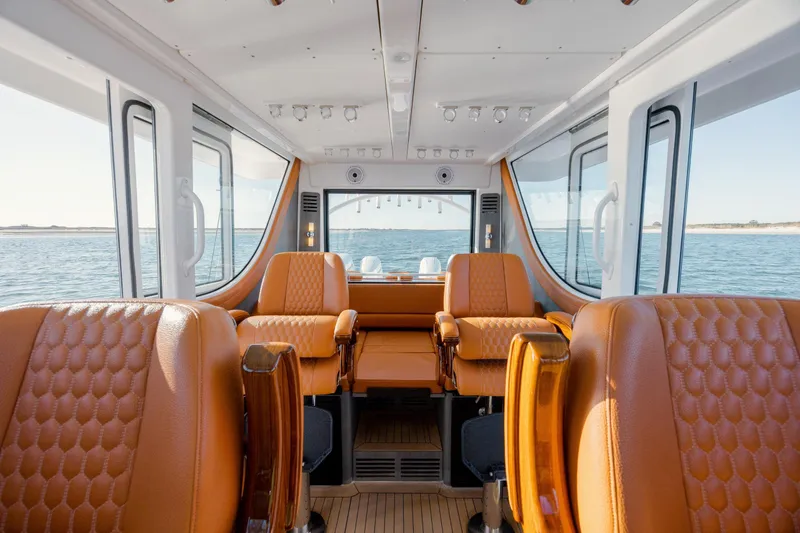  Yacht Photos Pics Luxurious interior of 2024 Invincible 46 Pilothouse yacht with leather seating and panoramic windows.