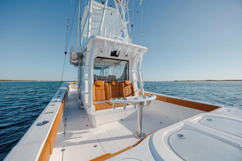  Yacht Photos Pics 2024 Invincible 46 Pilothouse boat on open water, showcasing sleek design and spacious deck.