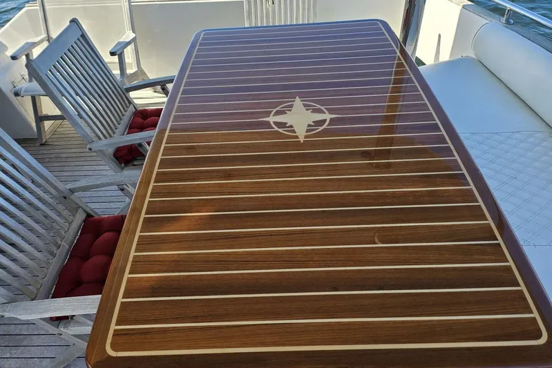  Yacht Photos Pics Elegant wooden table with compass design on a 2003 Johnson FLY yacht deck.
