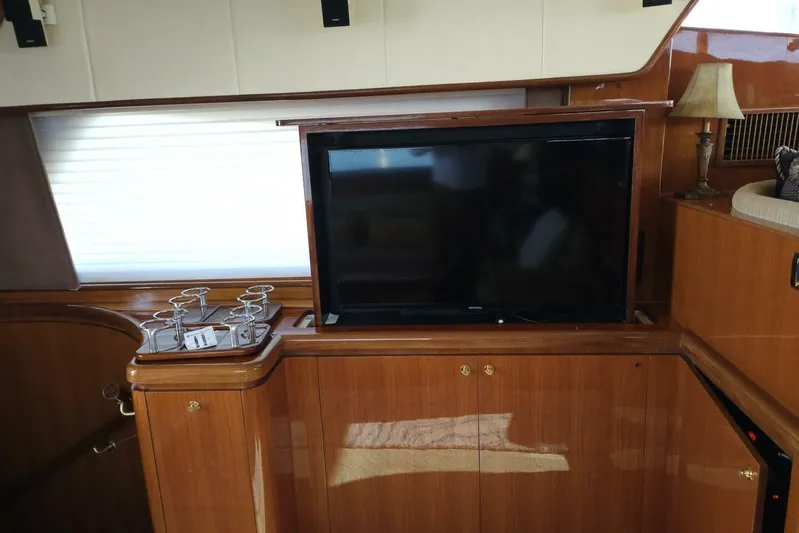  Yacht Photos Pics Luxurious interior of 2003 Johnson FLY yacht with TV and elegant wood finish.