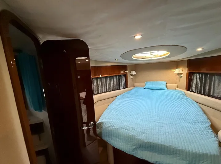  Yacht Photos Pics Luxurious 2009 Princess V53 yacht bedroom with blue bedding and elegant lighting.