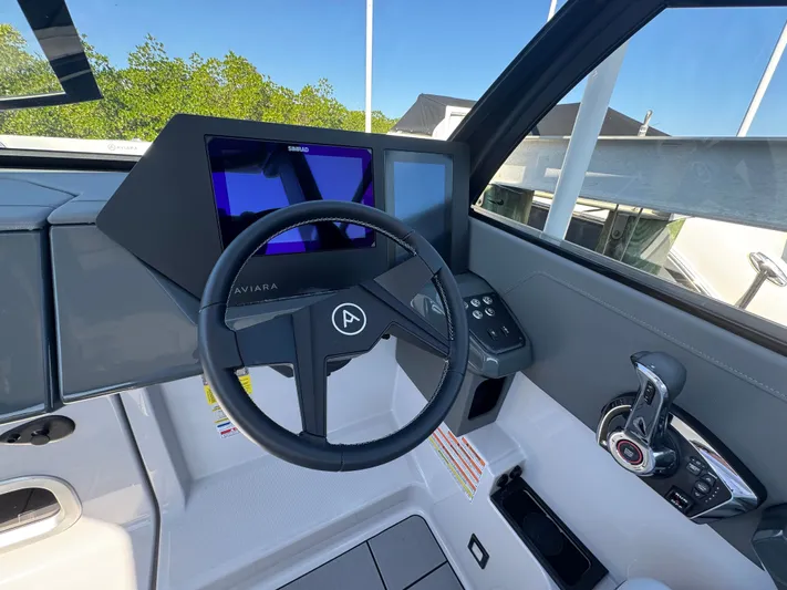  Yacht Photos Pics Interior view of Aviara 28 Surf 2025 cockpit with steering wheel and instruments.