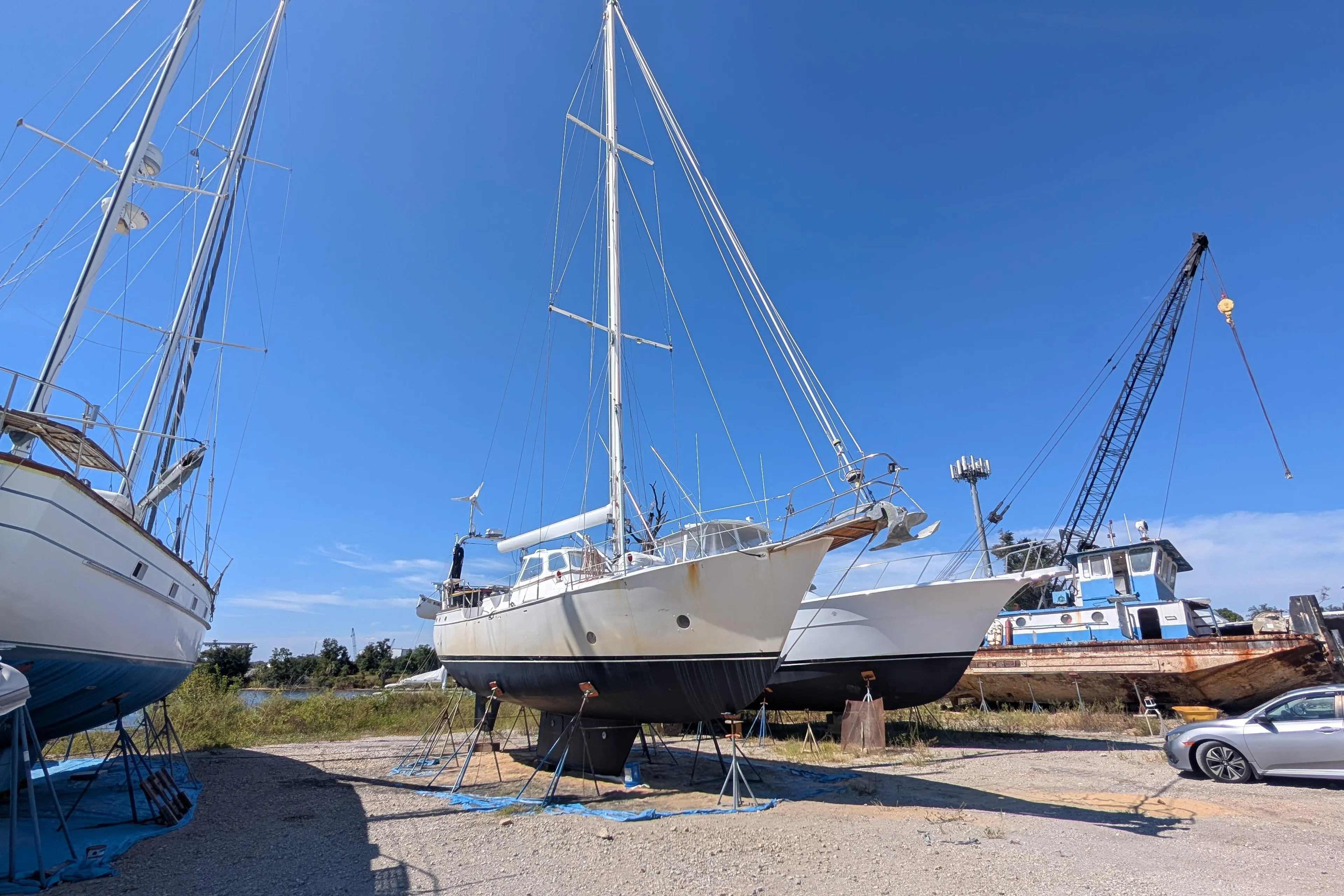 Bruce Bingham Custom 47 Steel Hull sailboat on land, 1992 model, with clear blue sky.