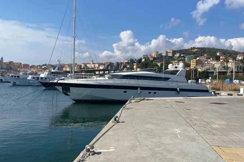  Yacht Photos Pics Luxurious 1996 Overmarine Mangusta 100 yacht docked in scenic marina.