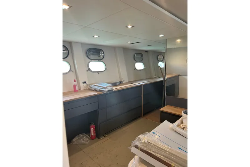  Yacht Photos Pics Interior of 1996 Overmarine Mangusta 100 yacht, featuring modern cabinetry and porthole windows.